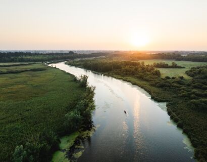 Ein Kanu paddelt auf der Peene aufgenommen aus der Vogelperspektive