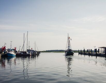 Ein Blick aus dem Hafen Altwarp, den gerade ein Segelboot verlässt.